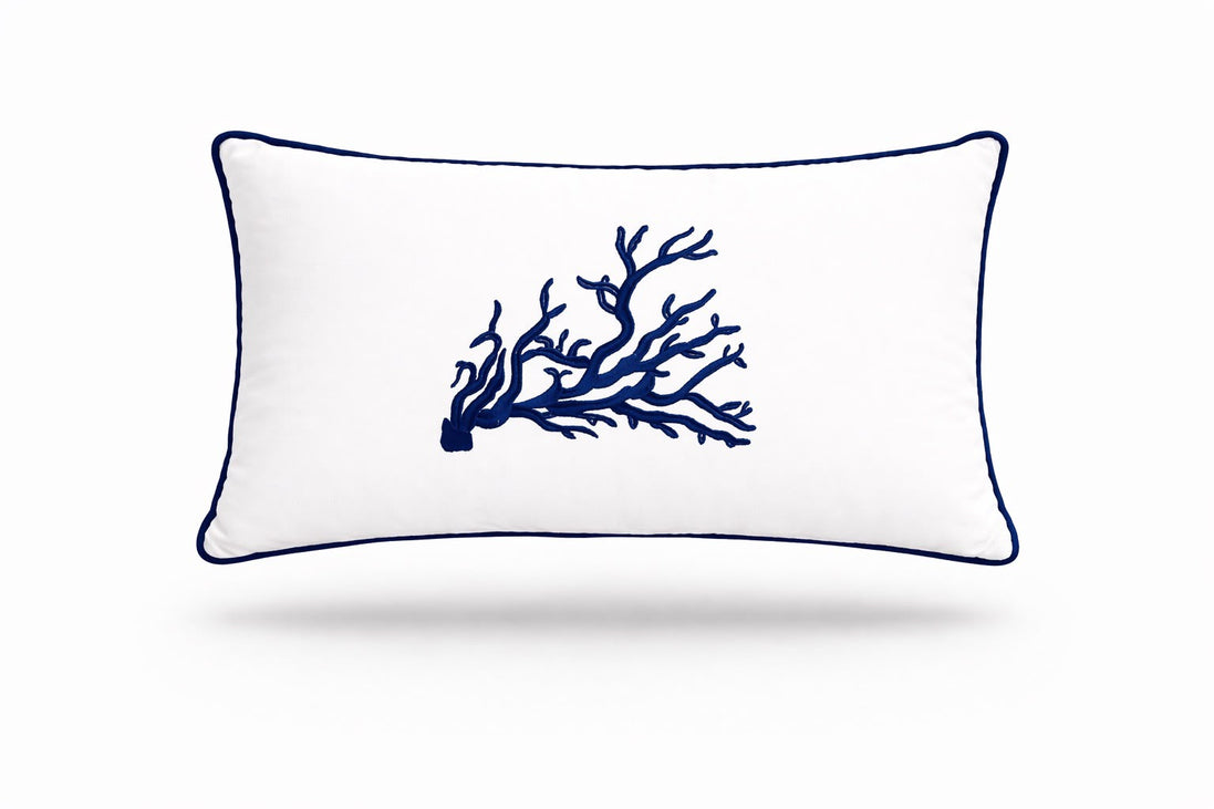 Navy coral embroidered across a white 35 x 55 cm outdoor cushion trimmed in navy piping