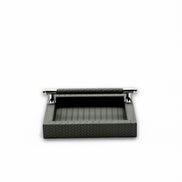 Grey napkin holder head-on, the leather-wrapped bar spanning two chromed posts above the open well
