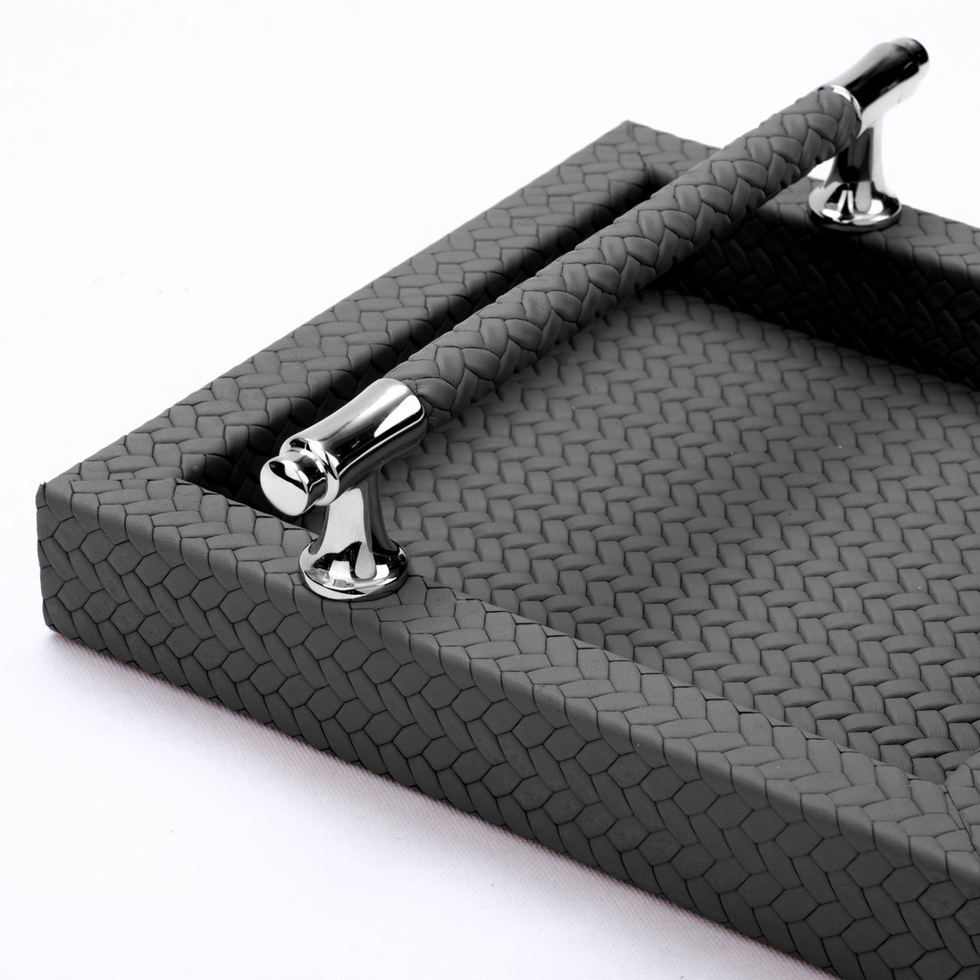 Detail of the leather-wrapped handle bar above the herringbone weave running across the base