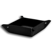 Black 18.5 × 18.5 cm valet tray from above, press studs pulling the woven-embossed corners together