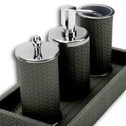 Grey woven leather bathroom set close up: chrome pump, lidded jar and tumbler standing on the tray