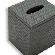 Top of the 14 x 12 cm tissue cover, its oval slot cut through the woven leather lid that overhangs the body