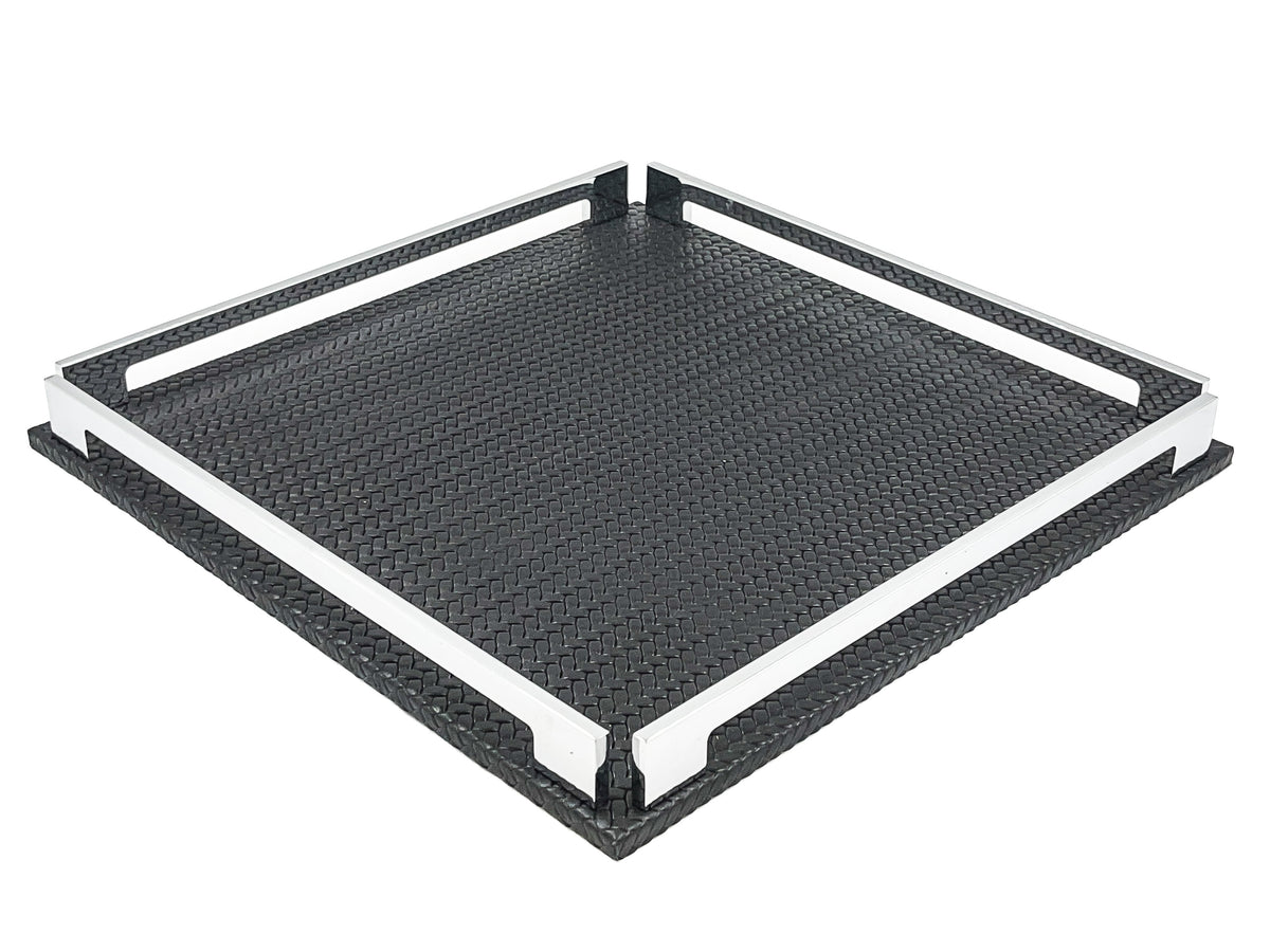 Black 37 × 37 cm square tray from above left, two full-length steel rails framing the woven-embossed leather floor