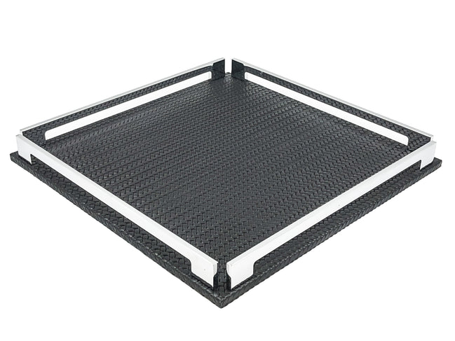 Black 37 × 37 cm square tray from above left, two full-length steel rails framing the woven-embossed leather floor