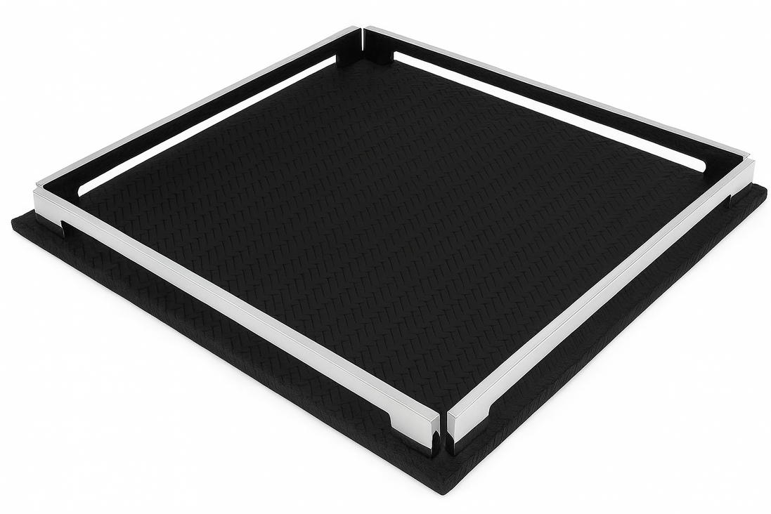 The black 37 cm tray seen almost flat on, one corner toward the viewer, steel rails bounding the dark leather field