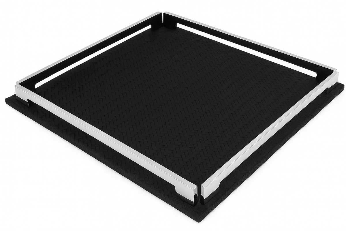 The black 37 cm tray seen almost flat on, one corner toward the viewer, steel rails bounding the dark leather field