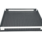 Low view of the black 37 cm tray, front steel rail across the frame and the leather floor receding behind