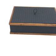 The 32 x 23 cm box closed, walnut rails capping lid and plinth around leather embossed in a scaled honeycomb