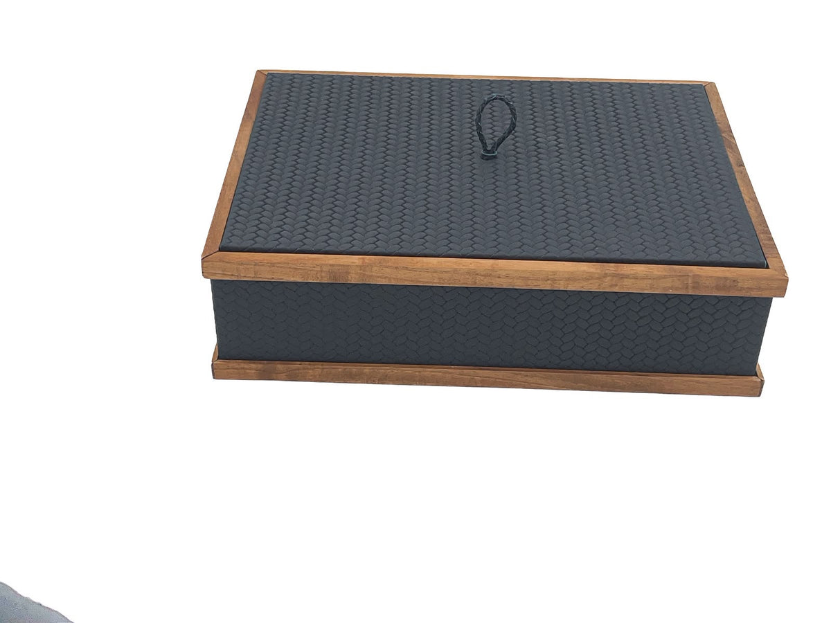 The 32 x 23 cm box closed, walnut rails capping lid and plinth around leather embossed in a scaled honeycomb