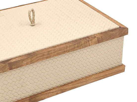 Close on the cream box, a braided leather pull standing on the lid inside its walnut rail