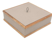 Pale greige box from above, its lid set flush inside a light walnut frame with a braided pull at the centre