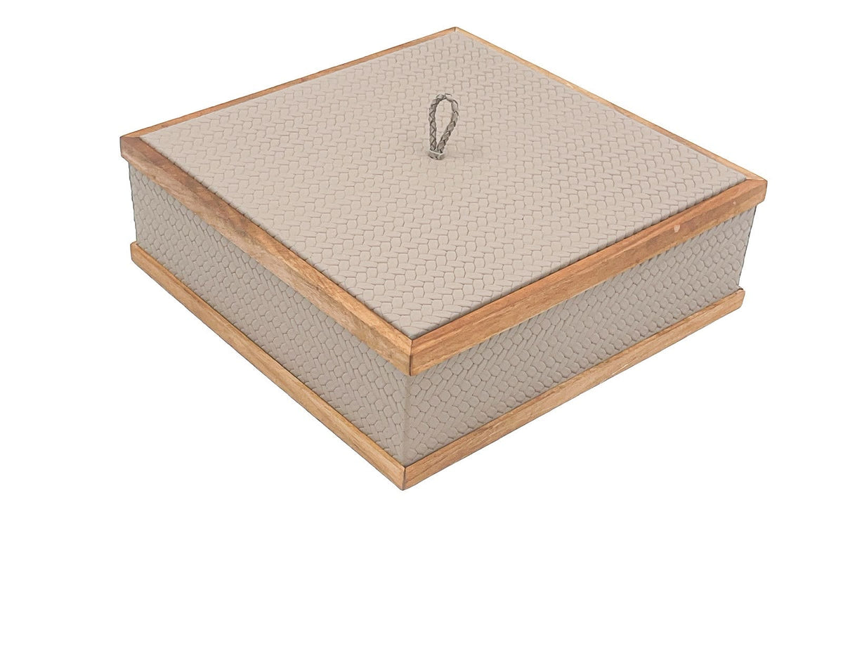 Pale greige box from above, its lid set flush inside a light walnut frame with a braided pull at the centre