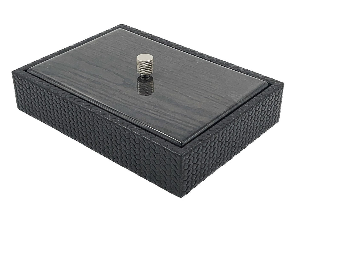 A leather box 5.5 cm deep with a lacquered wood lid, a knurled metal knob standing at its centre
