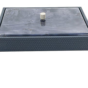 The lid seated flush inside a raised leather rim, the box wall below embossed in a fine chevron and 5.5 cm deep