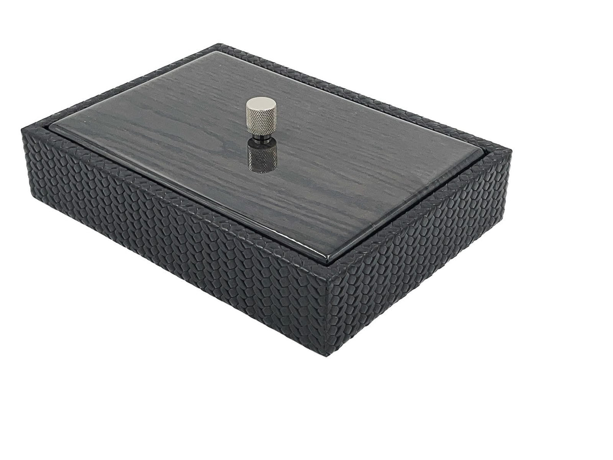 A leather box 5.5 cm deep with a lacquered wood lid, a knurled metal knob standing at its centre