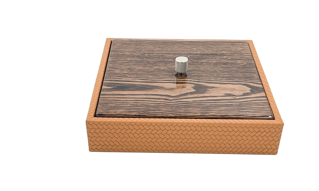 The 27 x 27 cm box closed at an angle, the knurled metal knob standing proud of the mahogany lid