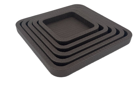 The five nested squares in brown leather from above and to the left, each wall stepping in toward the centre tray