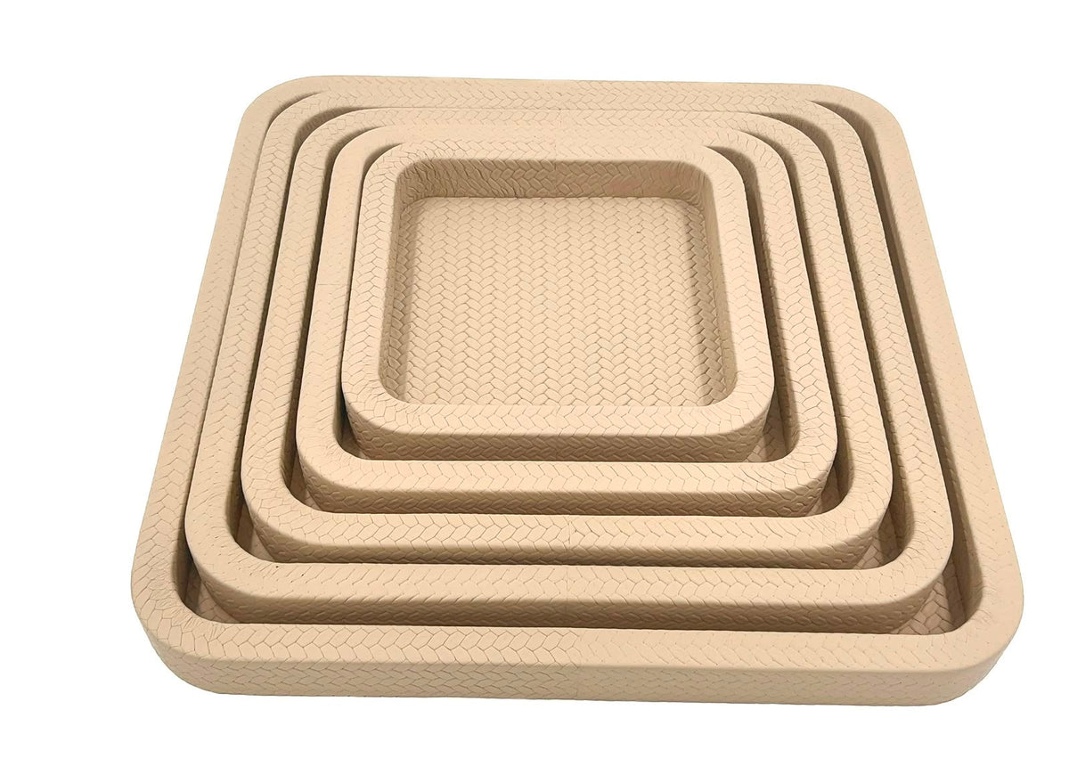 The nested set square on, the innermost tray's woven leather floor open at 22 cm across