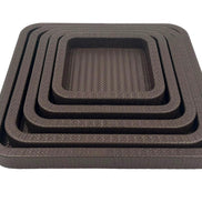 The nested set at eye level, five brown leather rims stacked above the 42 cm outer tray's 3.5 cm wall