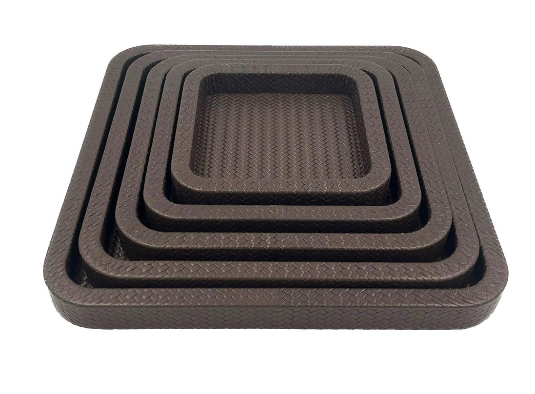 The nested set at eye level, five brown leather rims stacked above the 42 cm outer tray's 3.5 cm wall