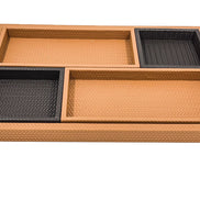 Four leather trays laid inside the base tray, two deep squares set diagonally against two long shallow ones