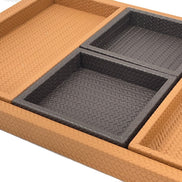 Close on two of the inner trays, their leather walls meeting square inside the deeper rim of the base