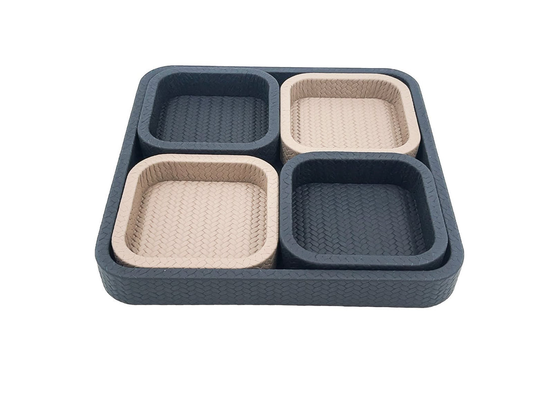 The 37 x 37 cm tray seen level, four compartments inside it alternating dark and pale leather