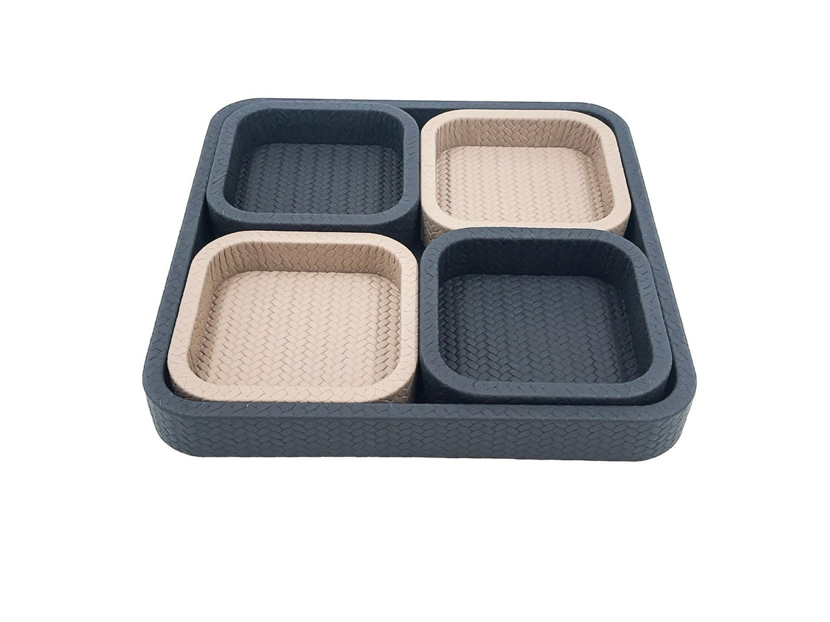 The 37 x 37 cm tray seen level, four compartments inside it alternating dark and pale leather