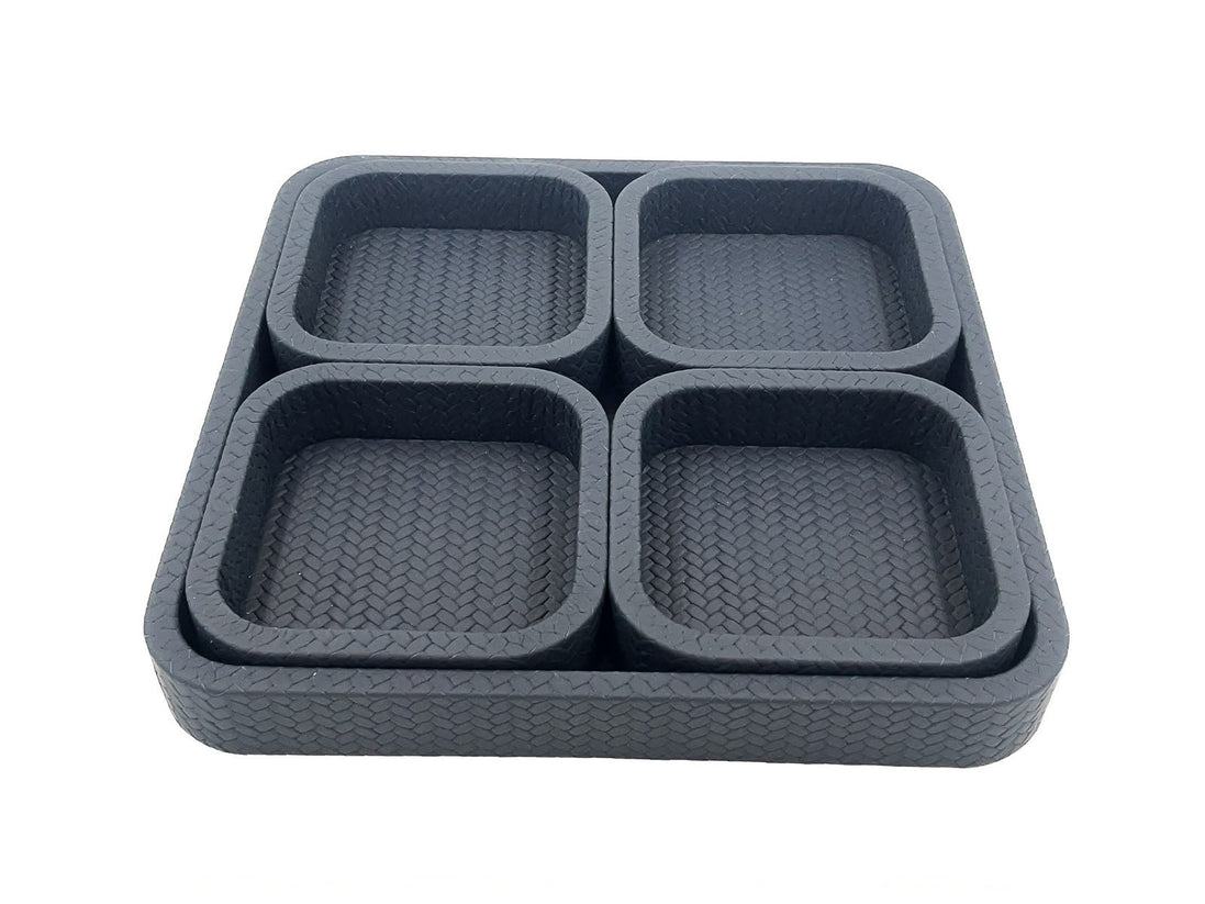 The charcoal set from above right, the base tray's woven leather visible between the four inset wells