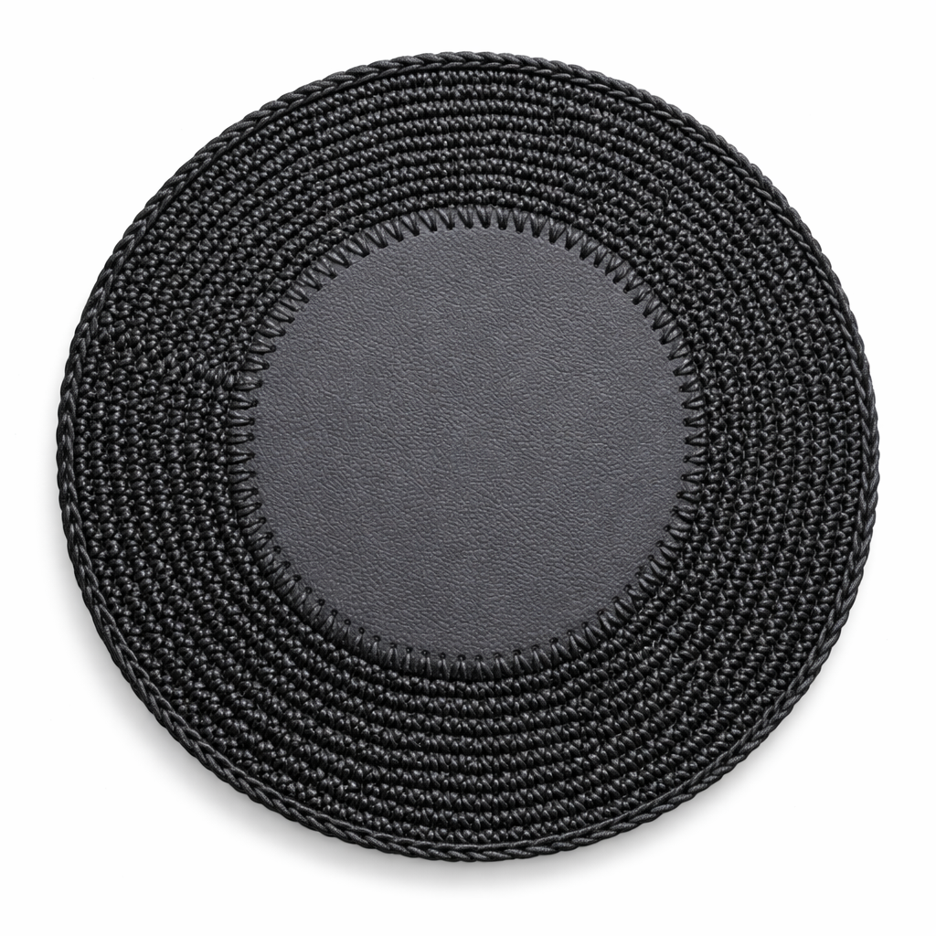 The 36 cm round placemat in black, its leather centre disc whipstitched into a crocheted cord border