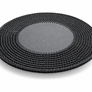 Black round placemat at an angle, the 1 cm crocheted border sitting flat around the leather centre