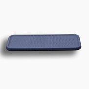 Navy placemat, its rounded corners and 1 cm edge reading dark against the ground