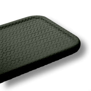 Macro of the khaki placemat corner, the woven-embossed leather cells and the softly rounded radius