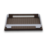 The brown 25 × 19 cm tray in full, steel handle rails standing above the woven-embossed leather floor