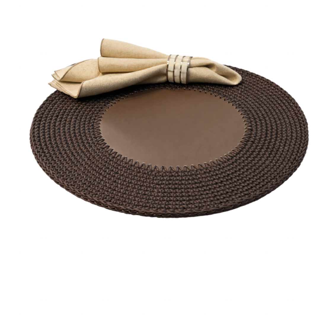 The brown placemat angled, linen napkin at its edge, leather centre ringed by crocheted cord