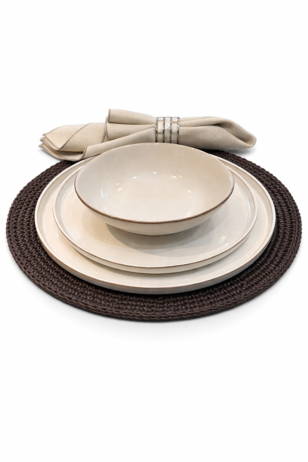 Cream plates and bowl stacked on the 36 cm brown placemat, linen napkin behind in a cord ring