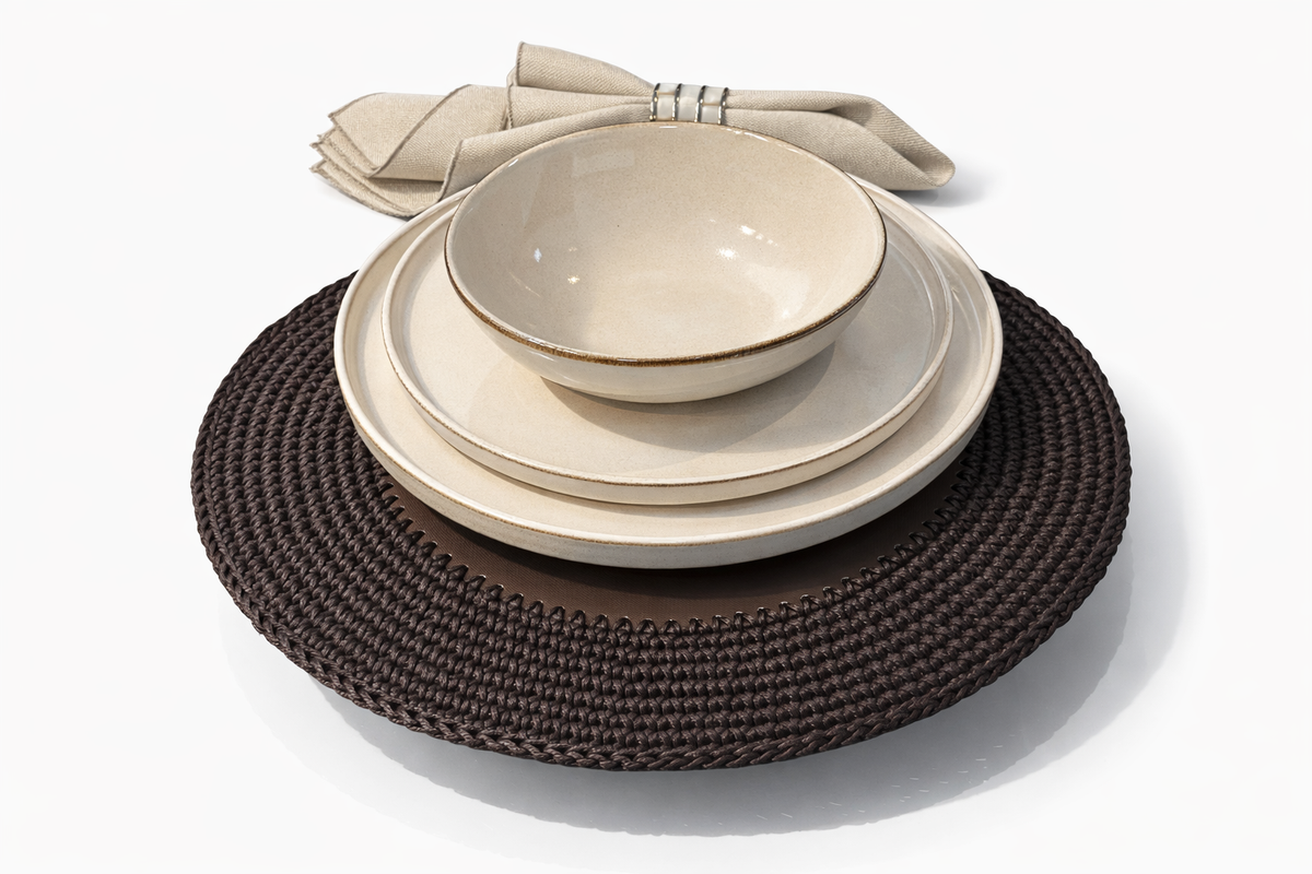 The 36 cm brown placemat laid with three cream ceramics, its cord border showing past the plate rim