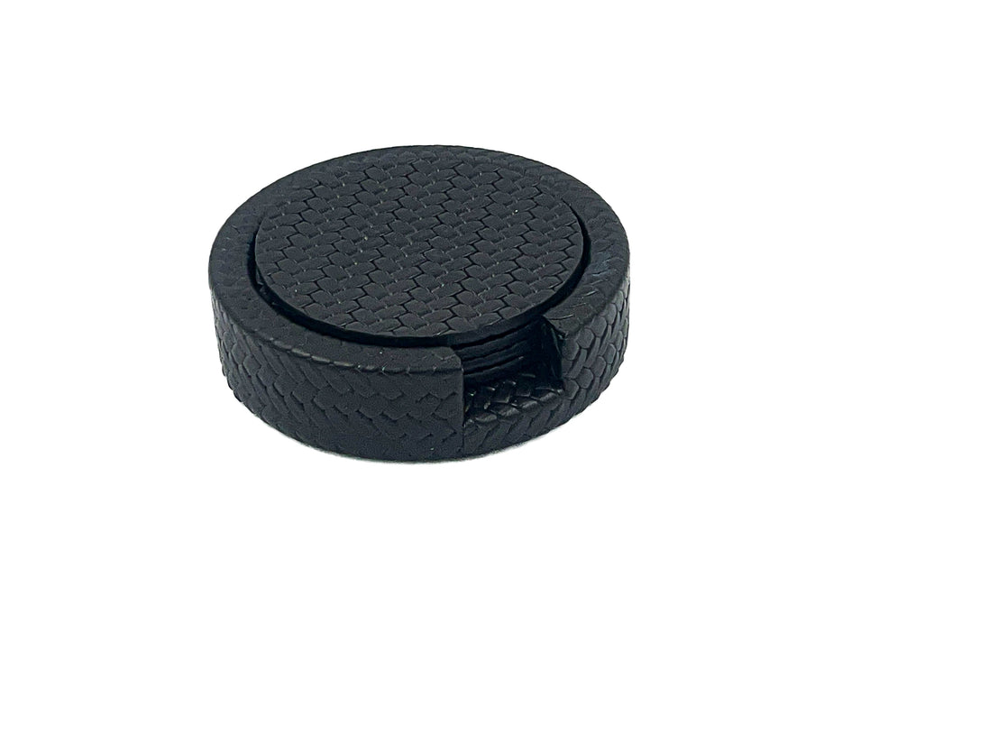 Navy Ø 10 cm leather coasters stacked in their round holder, woven-embossed faces and a notch cut in the rim