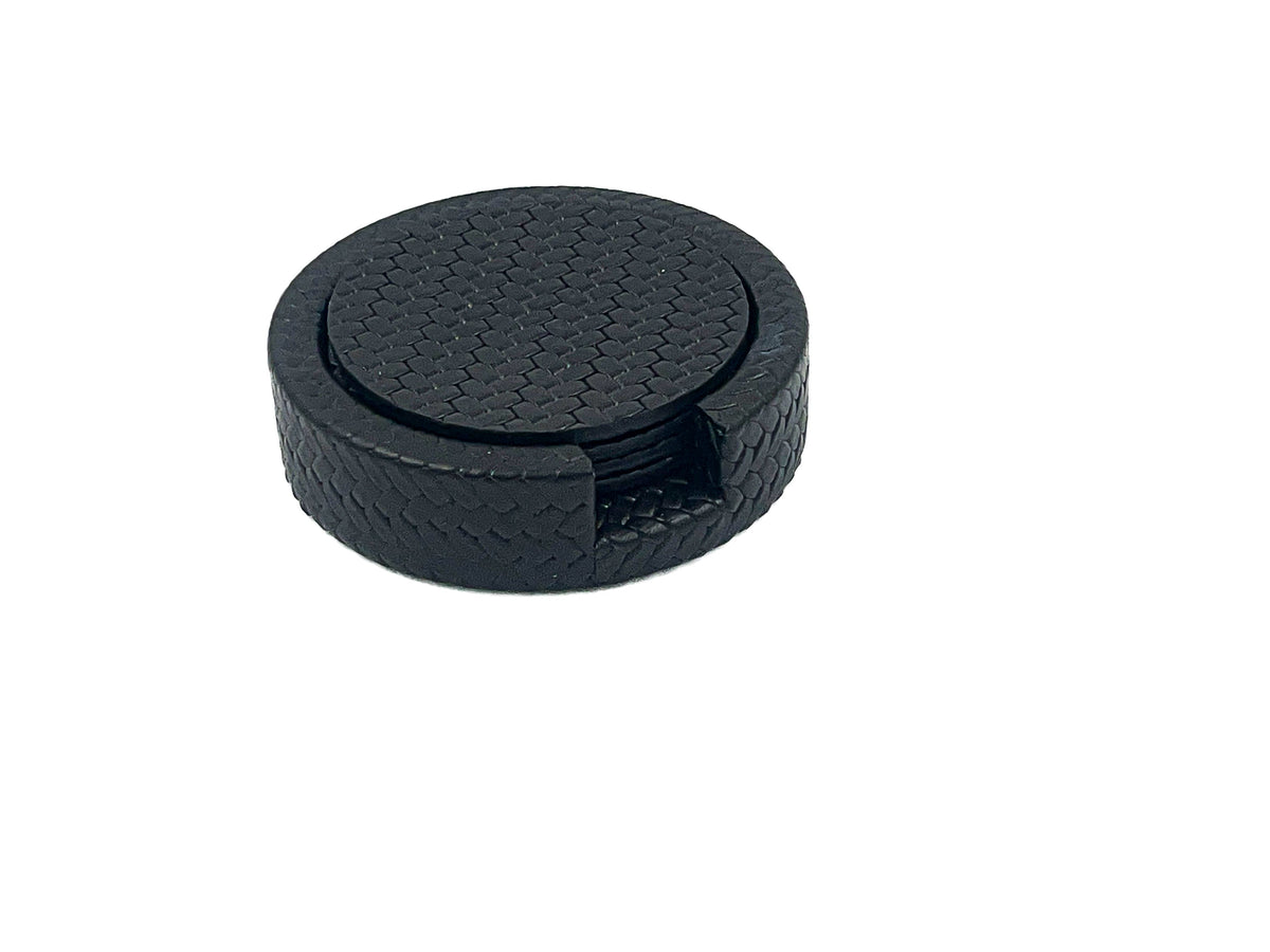 Navy Ø 10 cm leather coasters stacked in their round holder, woven-embossed faces and a notch cut in the rim