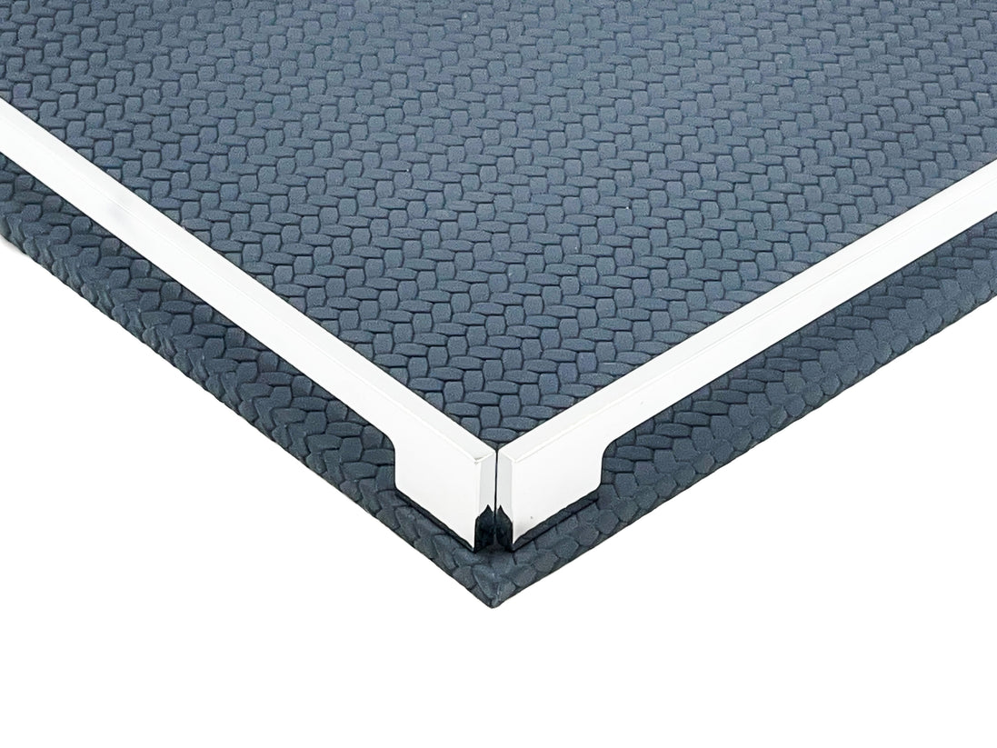Corner of the navy 37 cm tray close up, two steel rails meeting at the polished bracket over the leather weave