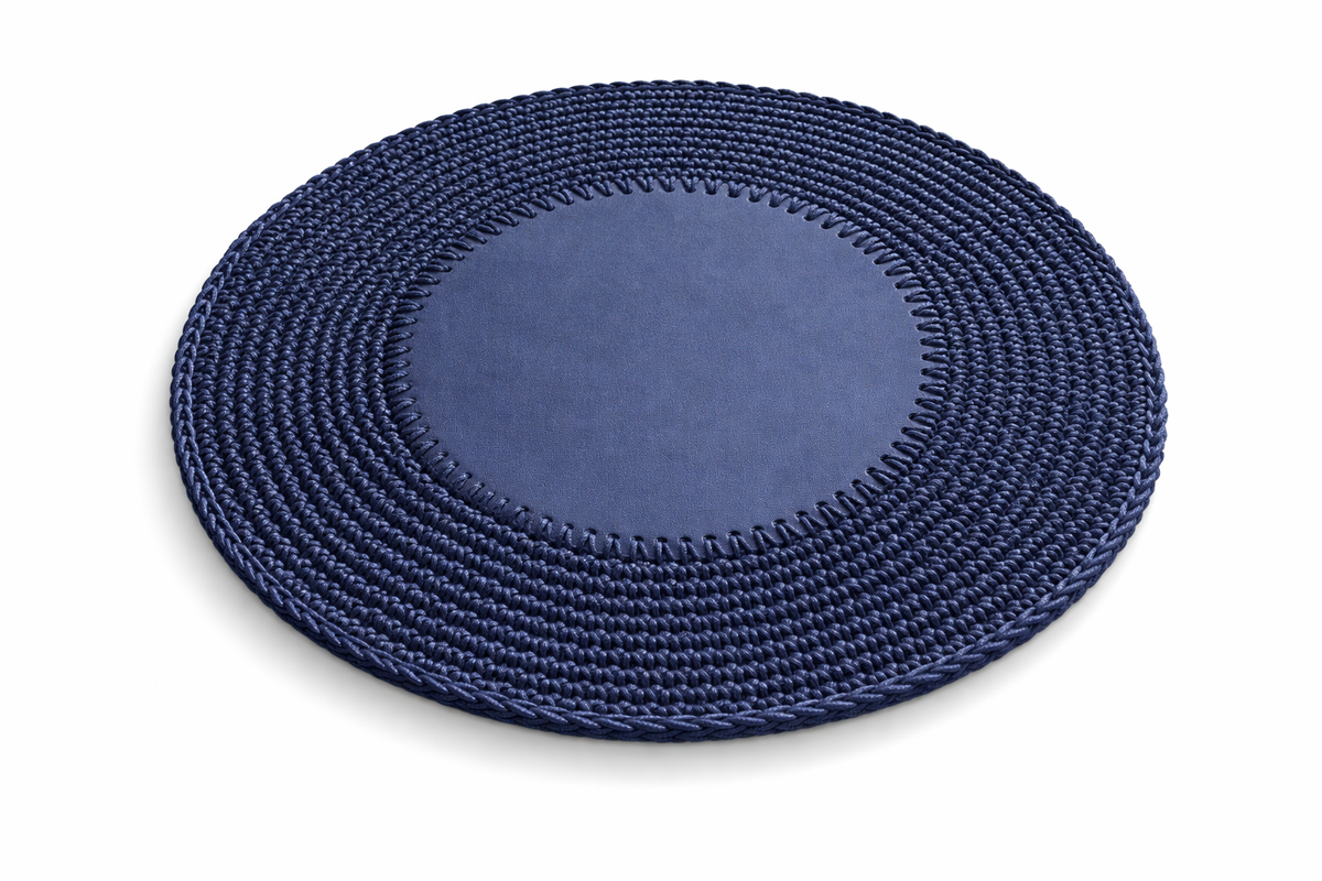 Navy round placemat at an angle, crocheted cord border ringing a 1 cm flat leather centre