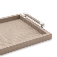 Close inside the beige tray, a handle rail and its polished steel collar above the woven leather floor