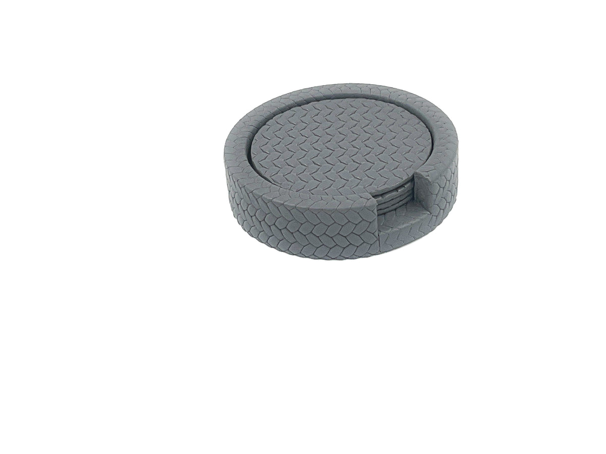 Grey coaster stack seen more from the side, woven-embossed leather rim around the Ø 10 cm discs