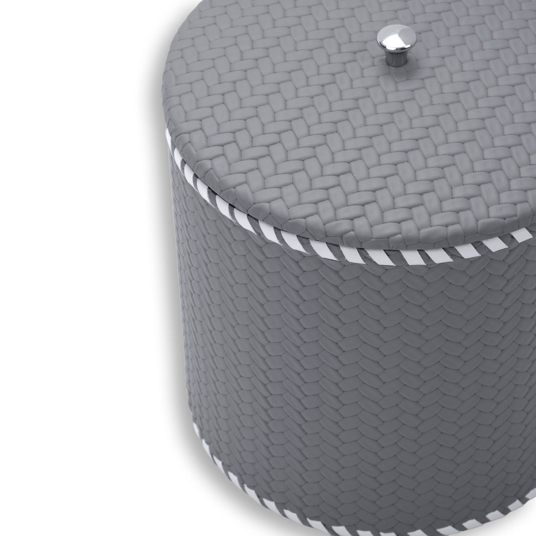 Close on the grey lid, faceted steel knob and woven-embossed leather at full scale above the laced rim