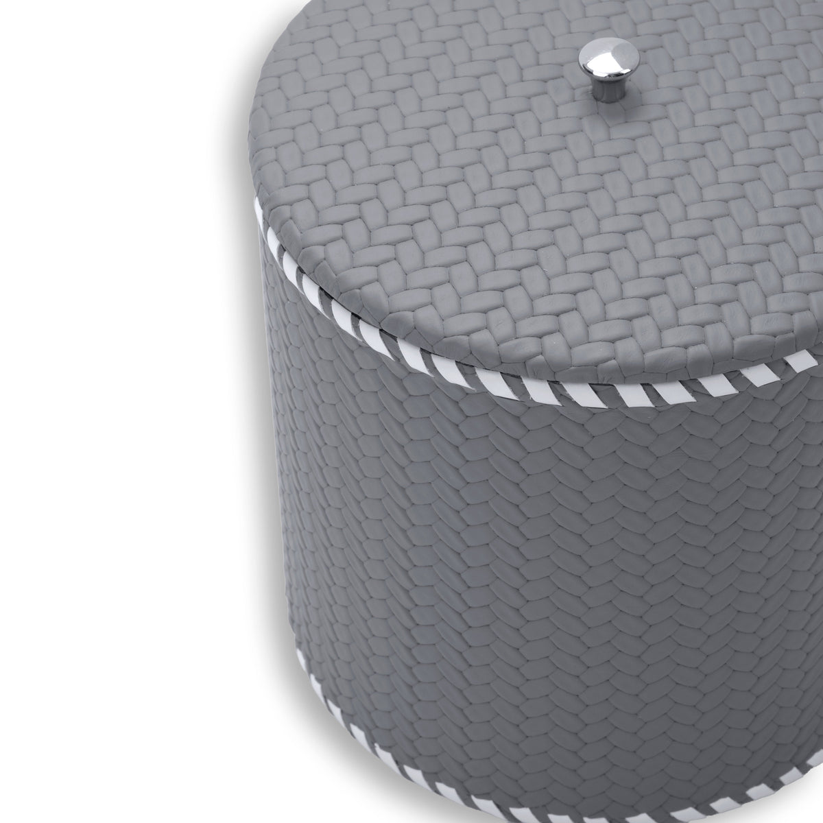 Close on the grey lid, faceted steel knob and woven-embossed leather at full scale above the laced rim