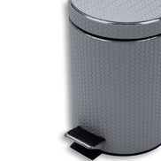 Close on the grey bin's body, woven-embossed leather at full scale above the chrome pedal