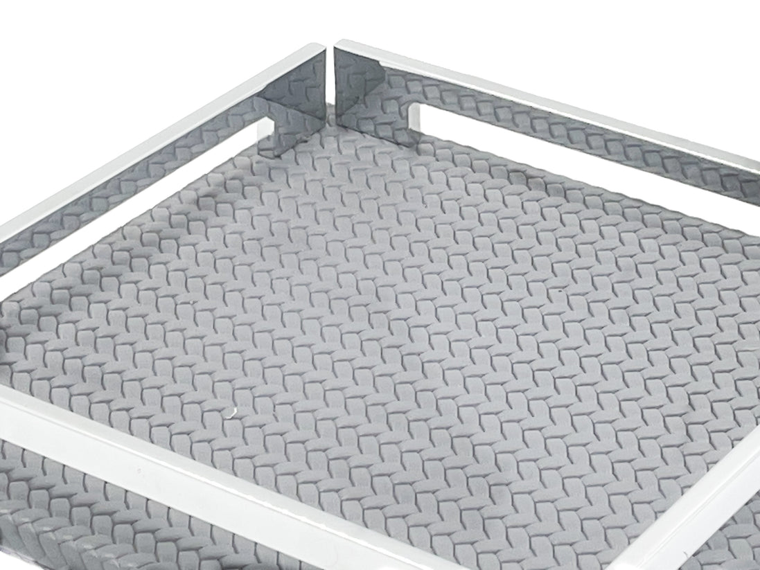 Close on the grey 25 cm tray, woven-embossed leather floor at full scale inside the steel rail