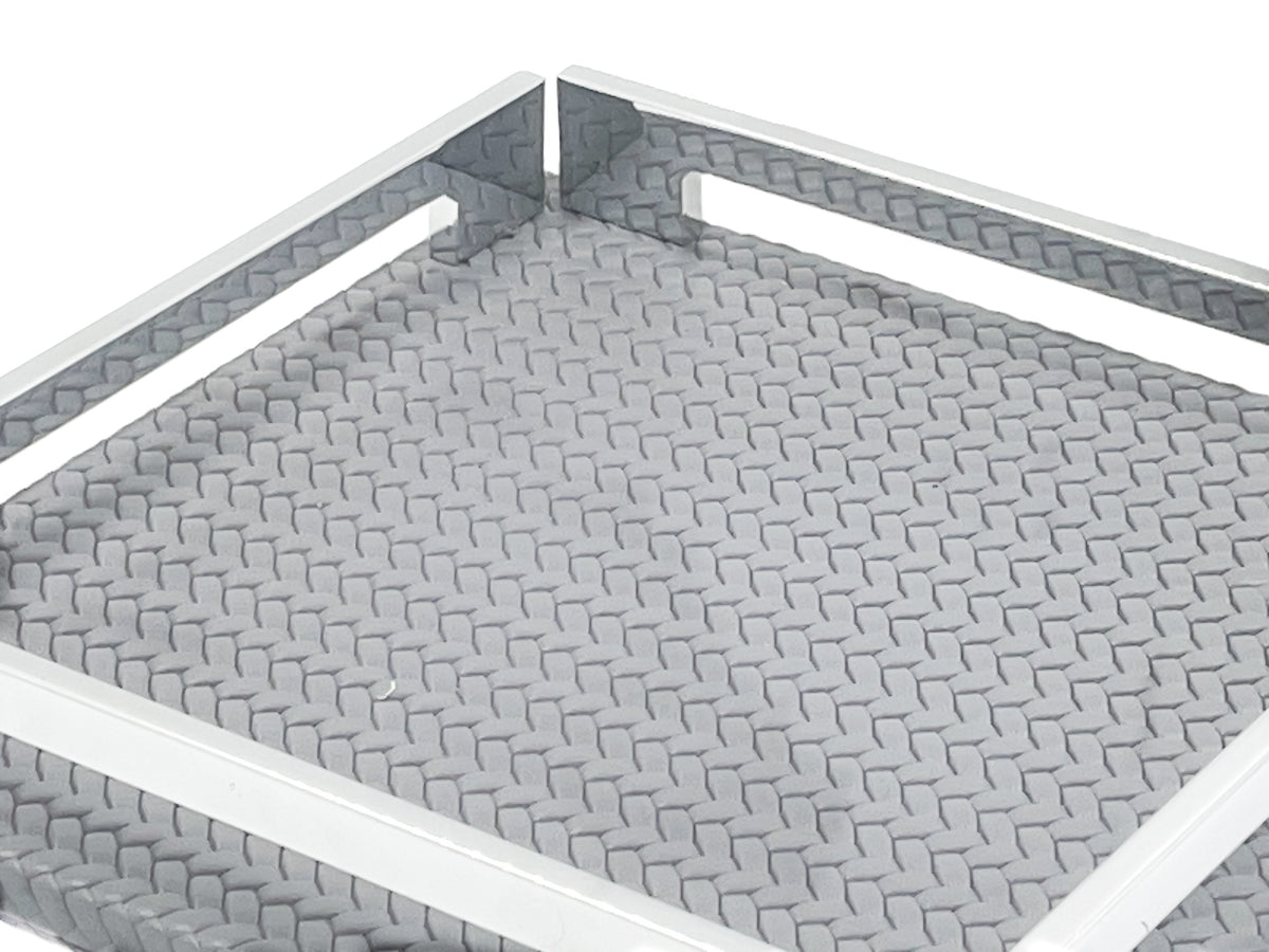 Close on the grey 25 cm tray, woven-embossed leather floor at full scale inside the steel rail