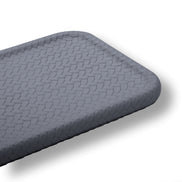 Close on the grey tray's rounded corner, the honeycomb leather emboss at full scale along the raised edge