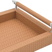 Close inside the tan tray, woven-embossed leather at full scale beneath a handle rail on its steel posts